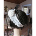 Delicate crochet acrylic stretch cream headband fasten with button at back and flower at side.