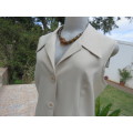 As new sleeveless cream jacket closing with 2 buttons and open collar. By SMILEY`S size 40/16.