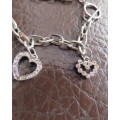 Cute chain bracelet with 3 hearts and 1 small key.With pinkish stones. Length 18cm.As new.