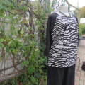 Black slip over top with long raglan sleeves. Front B/W animal print.100% polyester. Amara size 40.