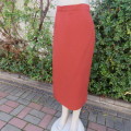 Elegant boutique made pencil skirt, fully lined in burnt orange. Size 42/18. In textured polyester.