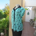 Cool sleeveless sheer turquoise poly top with black brush marks/collar/hidden button down.Size 36/12