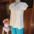 Lovely cream cotton capped sleeve slip over top. Braiding and colourful embroidery on front.Size 34.