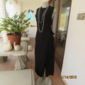 Elegant modern black jumpsuit with foldover skirt front. In 100% rayon.High collar.Size 38/14.As new
