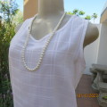 Lovely sleeveless slip over white top in creased polyester with embossed check pattern. Size 34/10.
