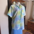 Beautiful short sleeve top in shades of blue and yellow. One cut pocket. Size 42/18. Rounded hemline