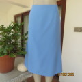As new sky blue A Line bandless skirt in calf length. In 100% polyester. Zip at back. Size 42/18.