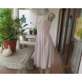 High quality sleeveless summer dress in ecru with white polkadots. Top lined. Pleated bottom.Size 34