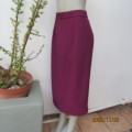 Elegant plum colour fully lined low calf length pencil skirt. Pleat and zip at back. Size 36.New con