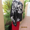 Cool loose slip over black top with bold white leaf design. Extended sides form sleeves.Size 42.