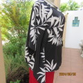 Cool loose slip over black top with bold white leaf design. Extended sides form sleeves.Size 42.