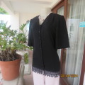 Charming black short sleeve V neck button down top/lace front hem. Size 33/9. Textured poly/viscose.