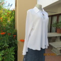 Pretty white polyester slip over top with long sleeves/flare cuffs. Front braided opening.Size 38/40