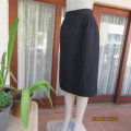 Chic and versatile black textured polyester fully lined pencil skirt size 36. Zip and pleat at back.