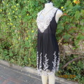 Feel sensational in this black poly netting richly white floral embroidered lined dress. Size 38/14.