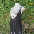 Feel sensational in this black poly netting richly white floral embroidered lined dress. Size 38/14.