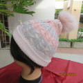 Sweet acrylic knit pom-pom hat in pink/blue cable stitch. Size small to medium. Very good cond.