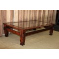AN EXQUISITELY CRAFTED SOLID WOODEN CENTER COFFEE/ OCCASIONAL TABLE WITH A TOUGHENED GLASS TOP