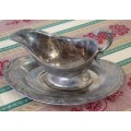 A BEAUTIFUL VINTAGE SILVER PLATED GRAVY BOAT AND UNDER PLATE WITH ORNATE DETAILING