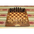 A SUPERB VINTAGE HAND-CARVED ORIENTAL FOLDING CHESS BOARD AND CARVED CHESS SET IN AWESOME CONDITION
