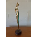 A wonderful tall solid brass abstract figurine mounted on a wooden base in great condition