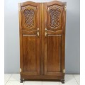 A stunning carved double-door solid Imbuia wardrobe with solid brass embellishments & ample space