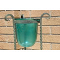 A gorgeous wrought iron plant stand with a large stunning emerald green glass bowl