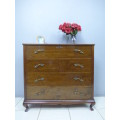 An exquisite vintage Oak 4-drawer chest of drawers with ornate handles and ample storage space
