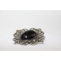 An exquisite silver metal ladies brooch with a large black oval bead stone in wonderful condition