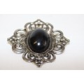 An exquisite silver metal ladies brooch with a large black oval bead stone in wonderful condition