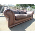 A stunning x-large modern styled brown genuine leather couch in great condition. RS17
