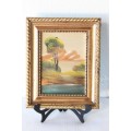 An amazing oil painting of a landscape framed in a lovely moulded frame
