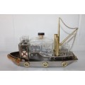 An amazing vintage tugboat decanter with a wind-up music box and four shot glasses
