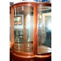 A stunning and beautifully made curved glass Teak show cabinet with solid brass embellishments