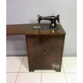 An incredible vintage (1930) singer "treadle" sewing machine in its cabinet in wonderful condition