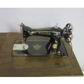 An incredible vintage (1930) singer "treadle" sewing machine in its cabinet in wonderful condition