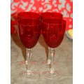 A stylish and modern boxed set of 4x tall wine glasses in a deep red colour with clear glass stems