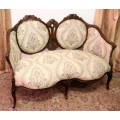 An exquisite antique Victorian carved settee with stylish new upholstery.