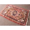 An awesome vintage/ antique? hand dyed Persian carpet (127cm x 80cm) with red and earthy tones