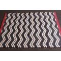 A beautifully made black and white "flat-weave" wool carpet with red edges in stunning condition