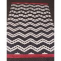 A beautifully made black and white "flat-weave" wool carpet with red edges in stunning condition