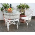 A gorgeous white painted wicker "all weather" outdoor/ patio table with a glass top and a chair