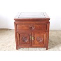 A beautifully carved oriental Elm wood "end" cupboard with brass symbol handles and a drawer