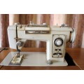 A vintage Empisal deluxe electric sewing machine in its original cabinet w/ accessories, working.