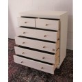 A tall 4-over-2 white painted chest of drawers with brass handles and ample storage space