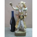 A carved ornamental Oriental wood figurine in traditional dress on a wood base. Lifespace Sale