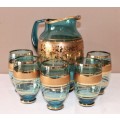 A unique set of matching cups with a jug decorated with gold gilt, perfect for entertaining guests.