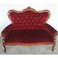A lovely antique mid-century two-seater carved English Teak red velvet button-back sofa