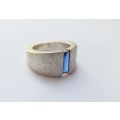 A thick heavy quality designer stamped sterling silver ring set with a faceted Sapphire