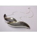 A CURVY LARGE STERLING SILVER CAST DESIGNER MADE PENDANT WITH A STERLING SILVER NECKLACE